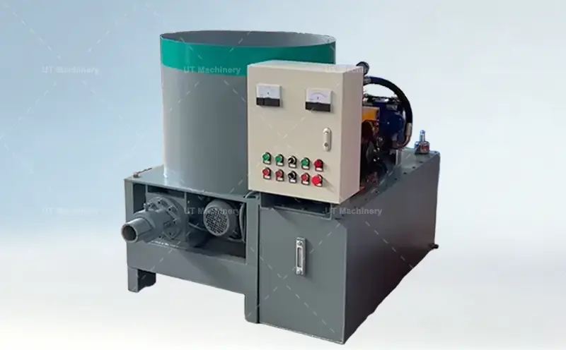 Máquina briqueteadora industrial de cáscara de arroz con una tolva grande de borde verde, un panel de control externo blanco con dos medidores analógicos y ocho botones de colores, y una salida frontal de descarga de briquetas.