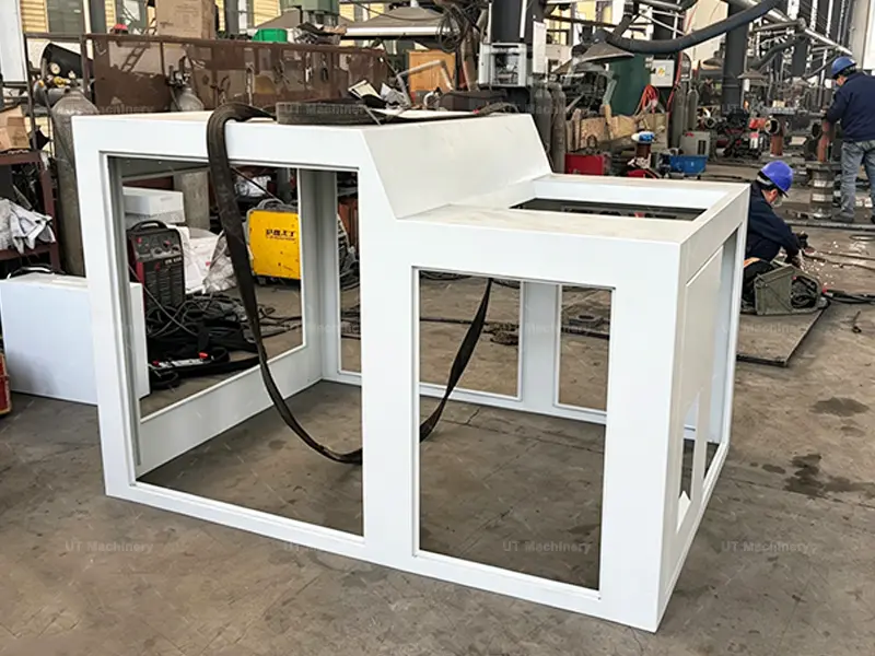 Soldadura y ensamblaje del bastidor estructural de acero de servicio pesado para la máquina briquetadora de metal dentro del taller de producción de UT Machinery.
