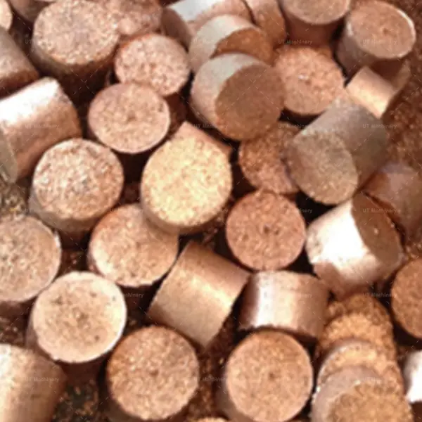 Un montón de briquetas cilíndricas terminadas de virutas pequeñas de latón, listas para el reciclaje metalúrgico y la fundición.