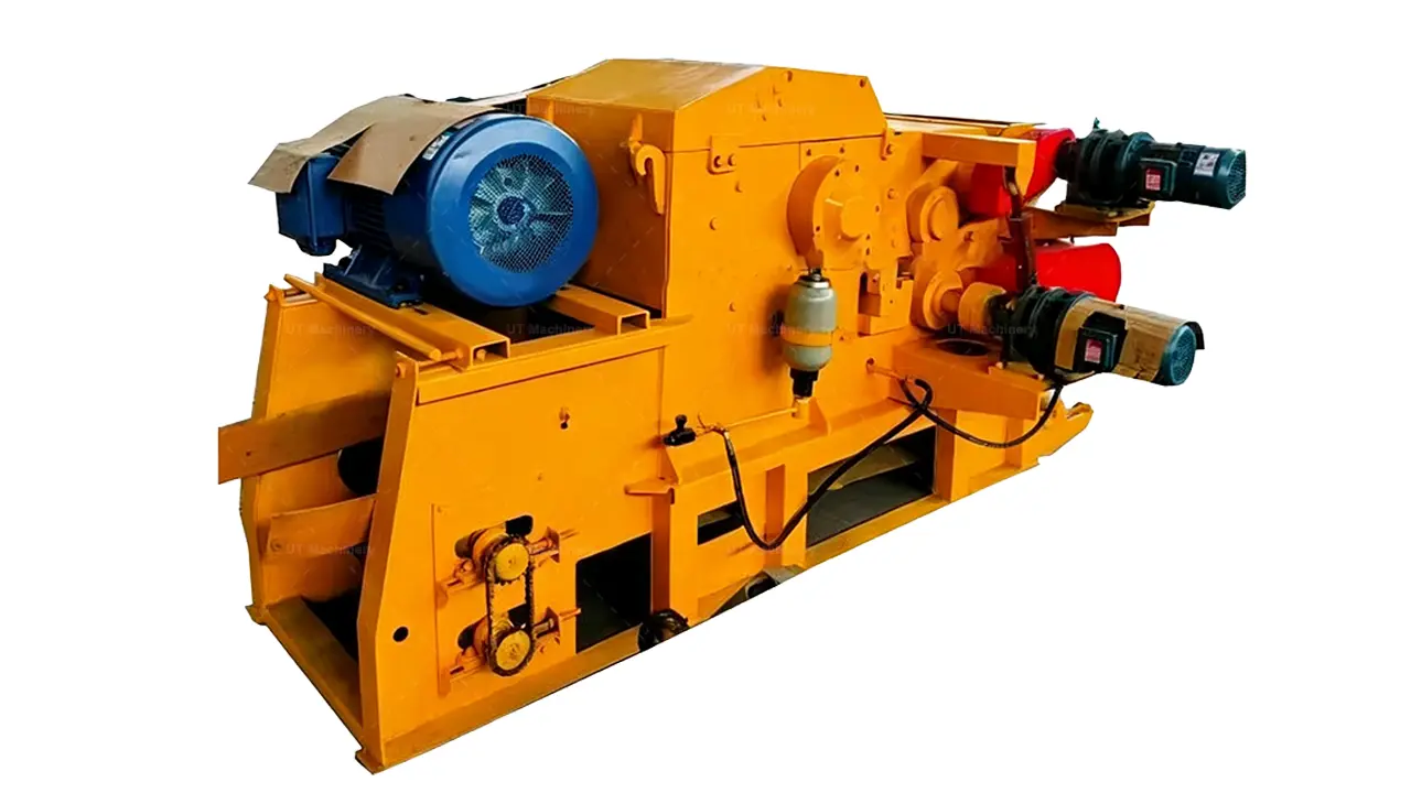 Primer plano detallado del mecanismo de trituracion central de una astilladora de tambor industrial amarilla, que muestra el motor de accionamiento azul, el sistema de poleas con proteccion roja y los componentes de tension hidraulica.
