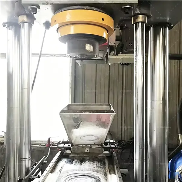 Tolva de alimentación por gravedad de acero inoxidable y cámara de cilindro de compresión de alta resistencia de una prensa vertical para briquetas de metal.